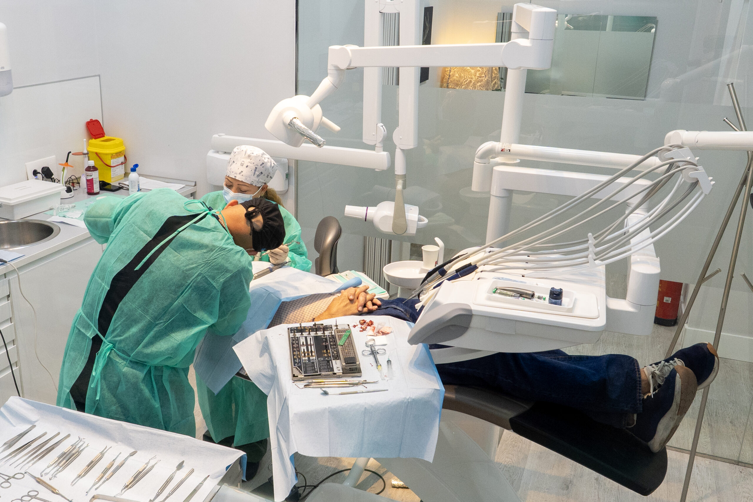 Prótesis dental fija real sostenida con guantes clínicos